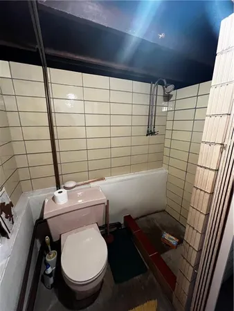 a white toilet sitting next to a shower