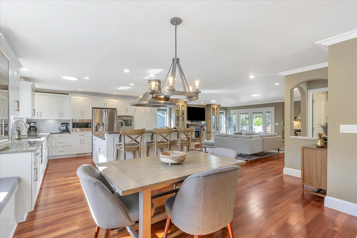 1261 Oddstad Boulevard Pacifica, CA 94044 - Photo 21 of 62 a view of a dining room and livingroom with furniture wooden floor a rug a fireplace and a chandelier
