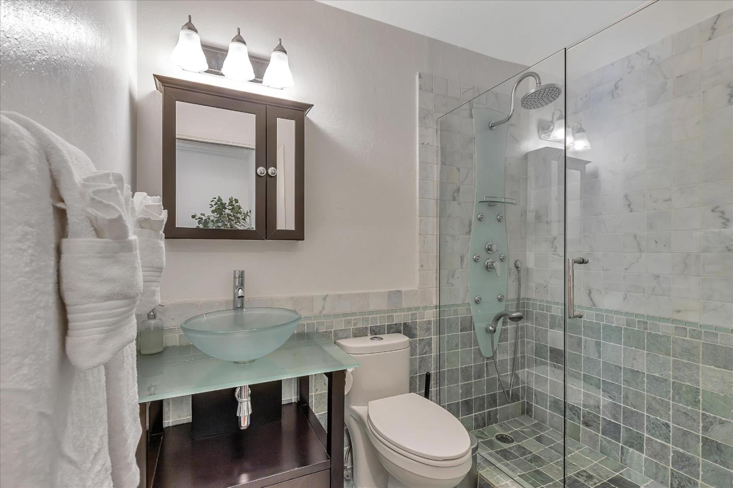 1261 Oddstad Boulevard Pacifica, CA 94044 - Photo 41 of 62 a bathroom with a toilet a sink a mirror a shower and vanity