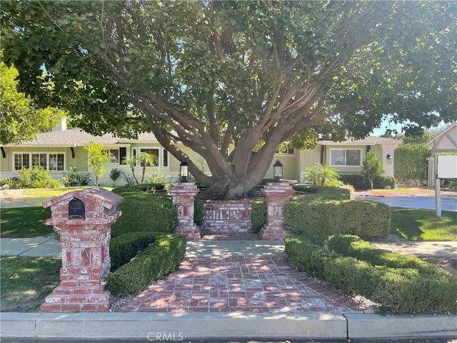 a front view of a house with yard and green space