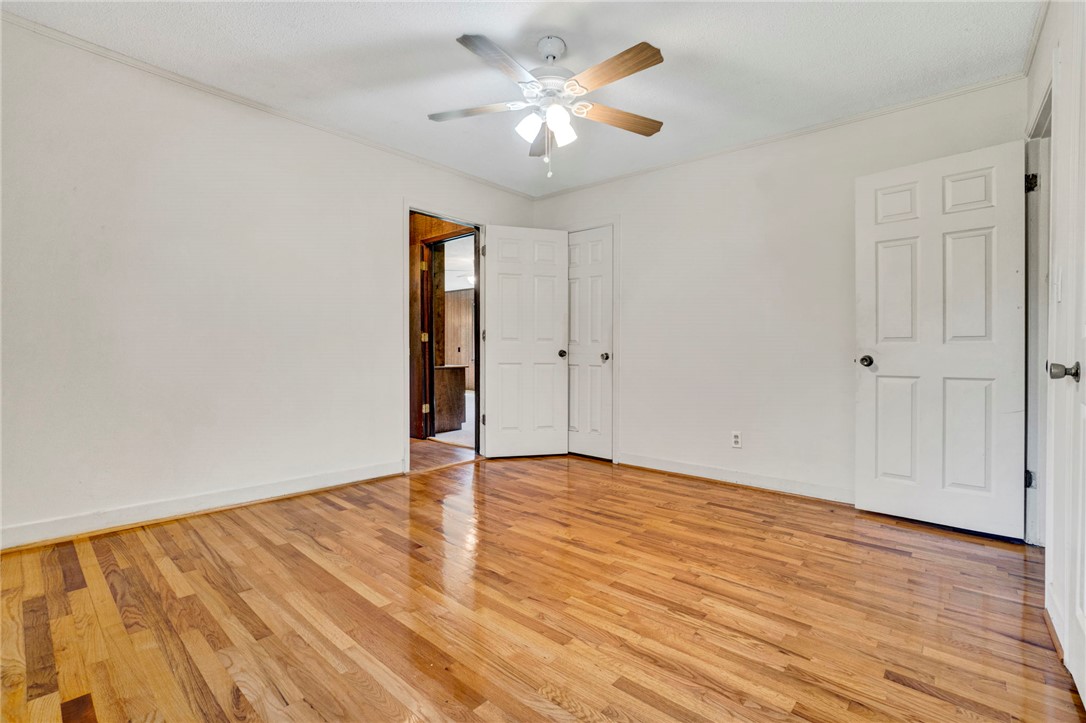7876 Highway 11 Walhalla, SC 29691 - Photo 26 of 35 Refined hardwood flooring graces this peaceful bedroom, illuminated by a classic ceiling fan for ultimate comfort.
