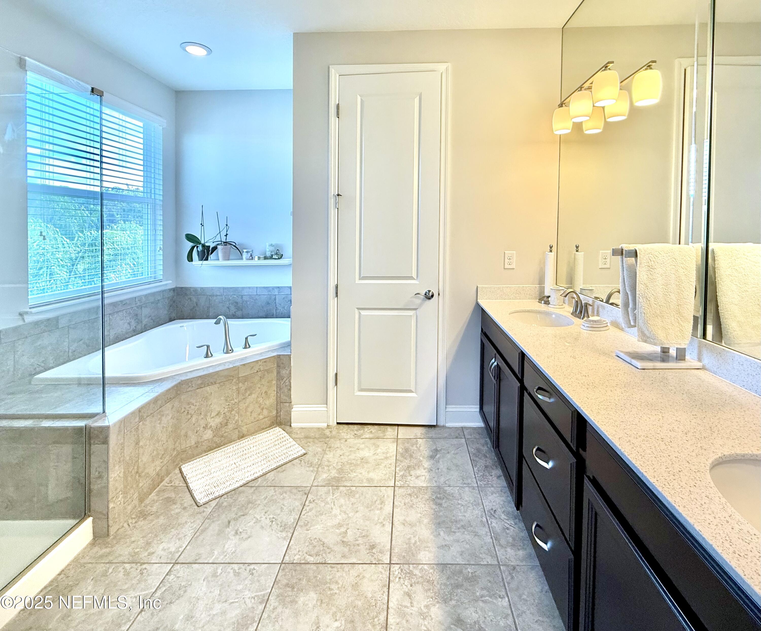 6887 Azalea Grove Drive Jacksonville, FL 32258 - Photo 21 of 35 a spacious bathroom with a tub sink and mirror
