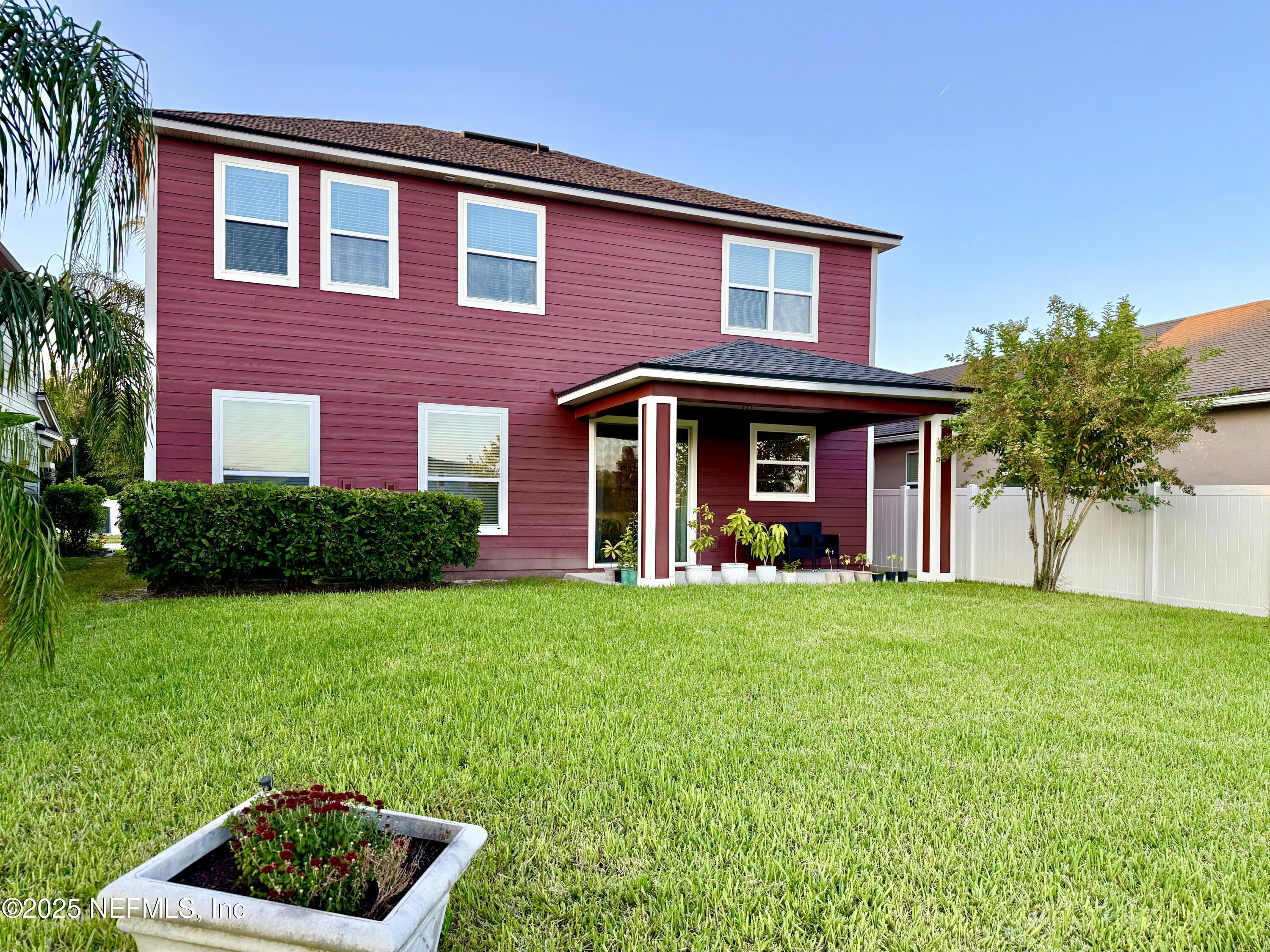 6887 Azalea Grove Drive Jacksonville, FL 32258 - Photo 35 of 35 a view of a brick house with a yard potted plants and a table