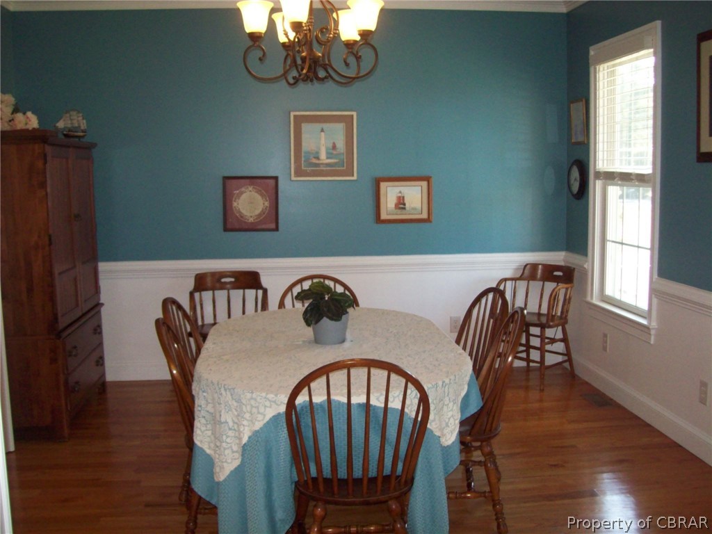 672 Lillys Neck Road Moon, VA 23119 - Photo 23 of 49 a view of a dining room with furniture wooden floor and chandelier
