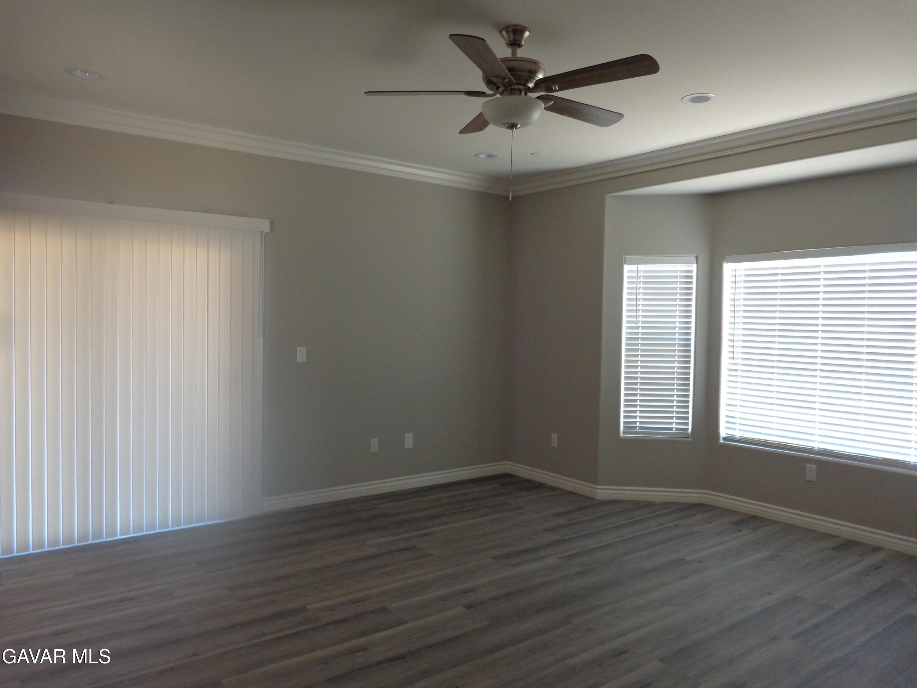 18255 Winnetka Road Apple Valley, CA 92307 - Photo 19 of 33 an empty room with wooden floor and windows
