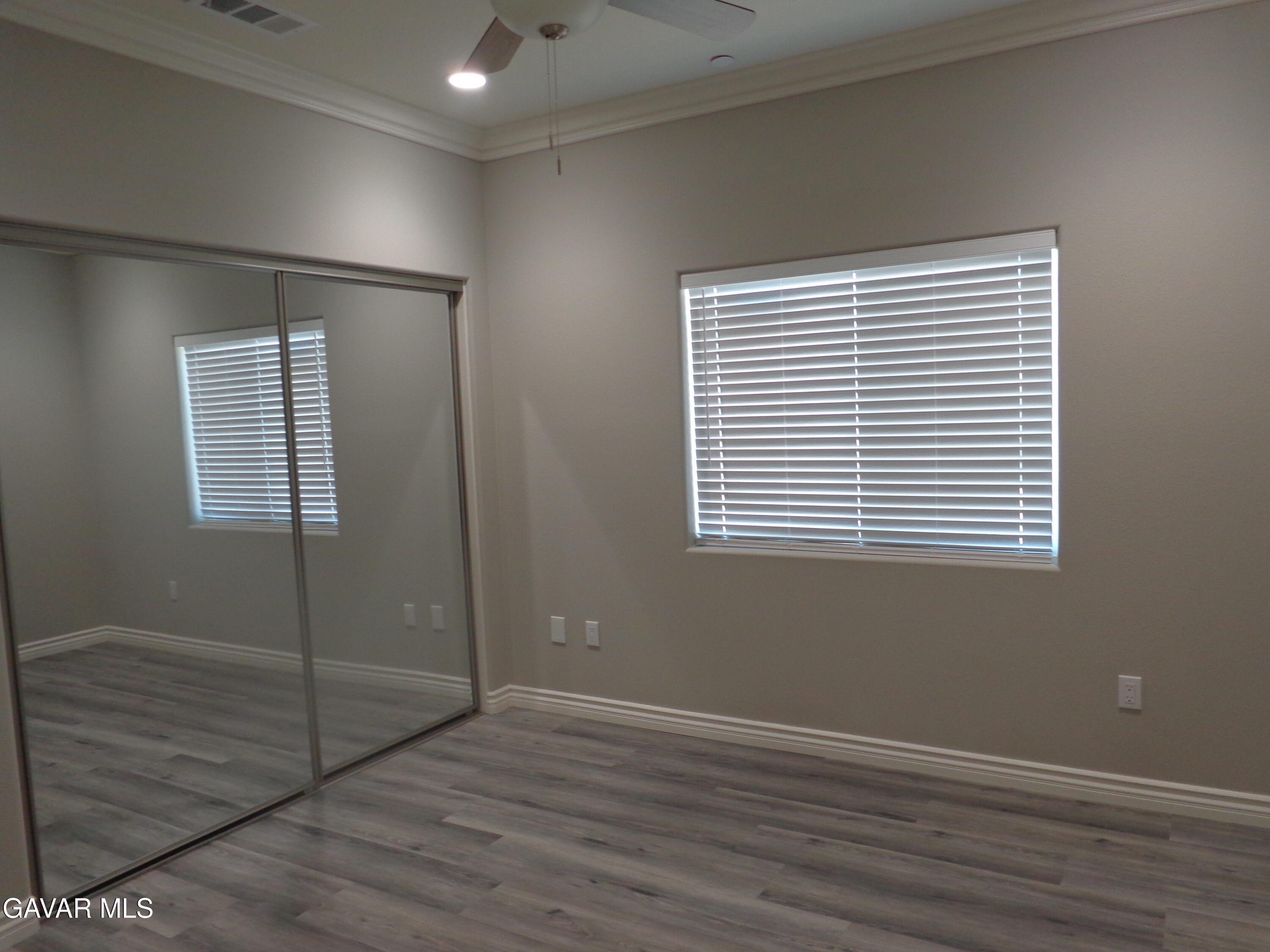 18255 Winnetka Road Apple Valley, CA 92307 - Photo 20 of 33 an empty room with wooden floor and windows