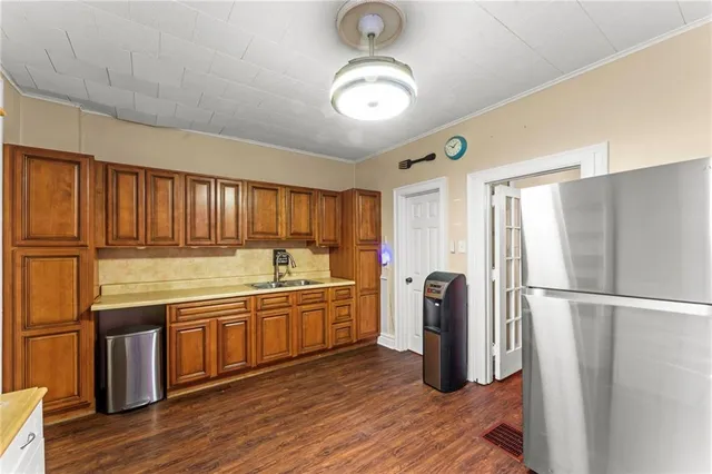 a kitchen with stainless steel appliances granite countertop a refrigerator a stove and a sink