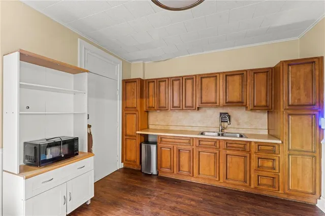 a kitchen with a sink cabinets and wooden floor