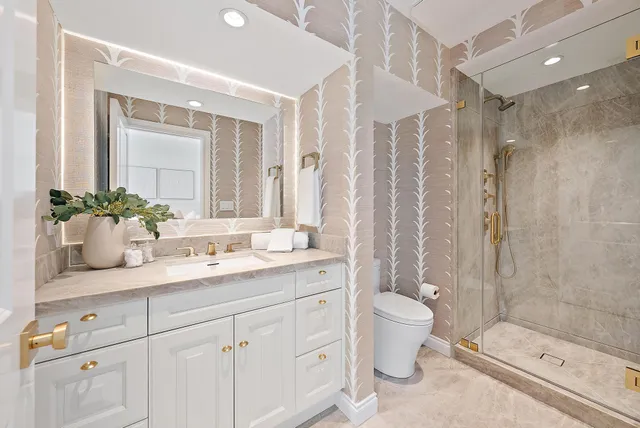 a bathroom with a sink a toilet and a large mirror