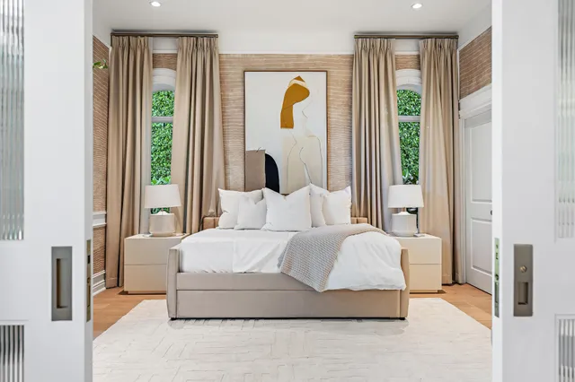 a bedroom with a bed lamp and a large window