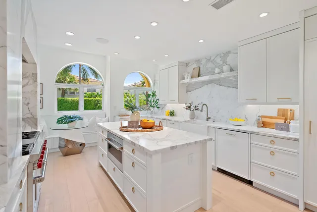 a kitchen that has a lot of white cabinets and wooden floor