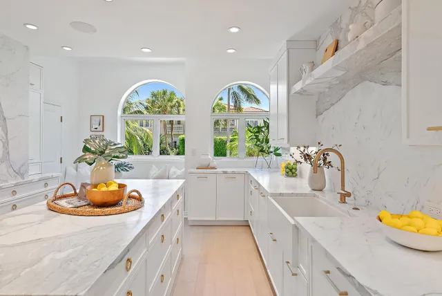 a large white kitchen with lots of counter space and window