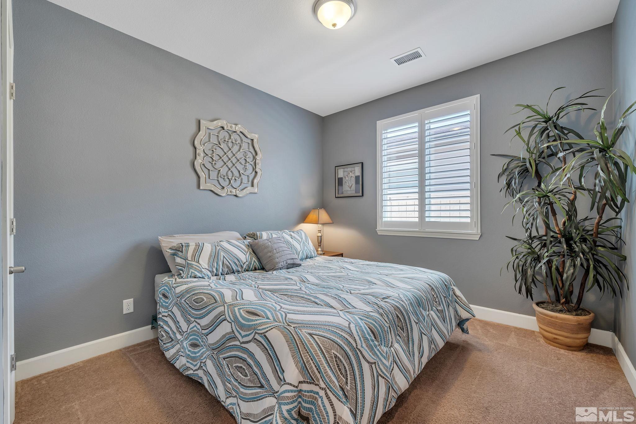 10128 Quintana Drive Reno, NV 89521 - Photo 24 of 34 a bedroom with a bed and a potted plant