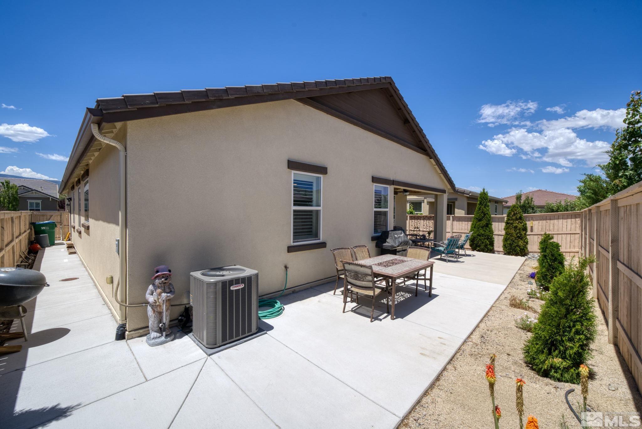 10128 Quintana Drive Reno, NV 89521 - Photo 30 of 34 a view of a patio with table and chairs with wooden fence