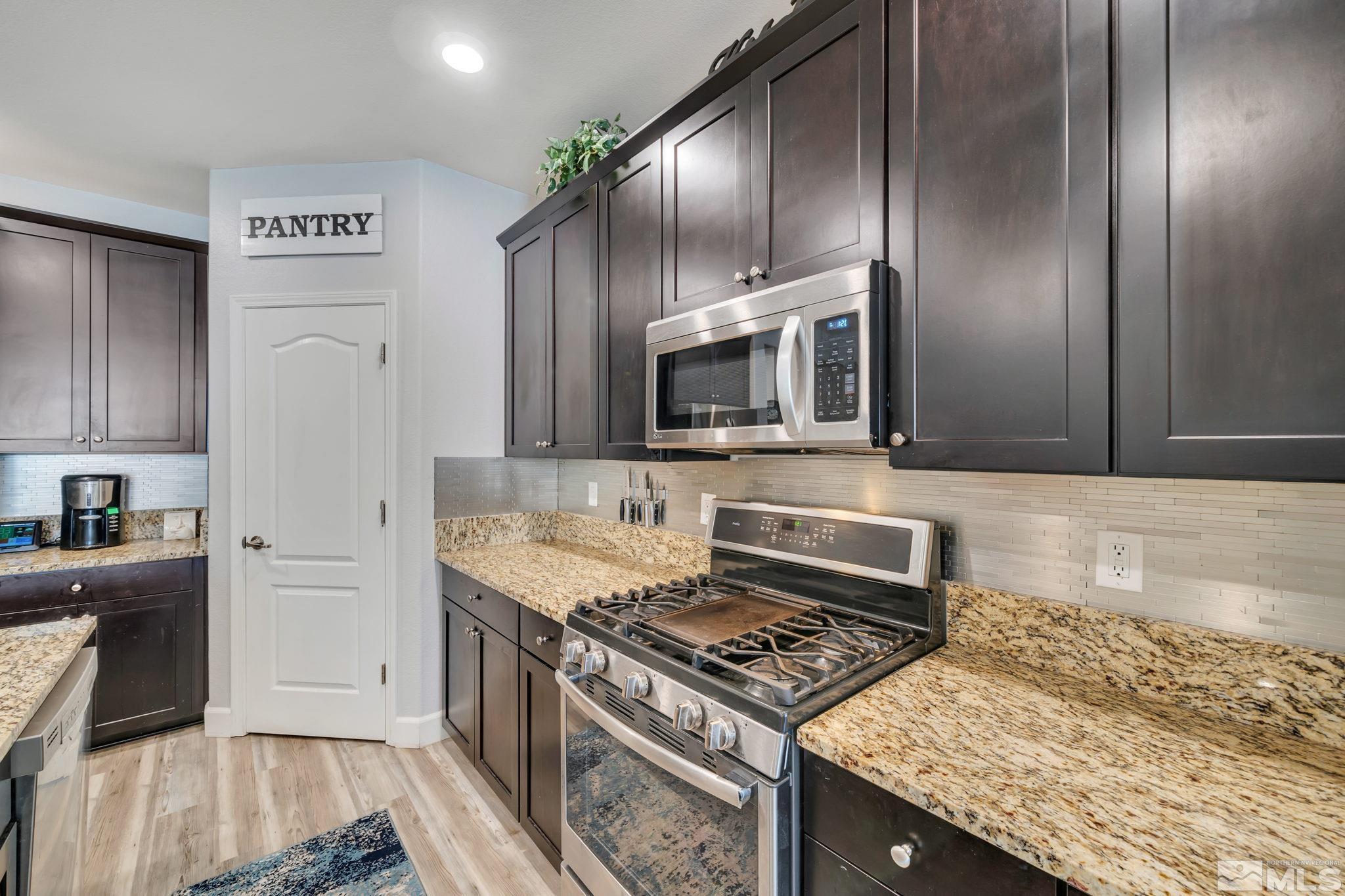 10128 Quintana Drive Reno, NV 89521 - Photo 10 of 34 a kitchen with stainless steel appliances granite countertop a stove a sink and a refrigerator