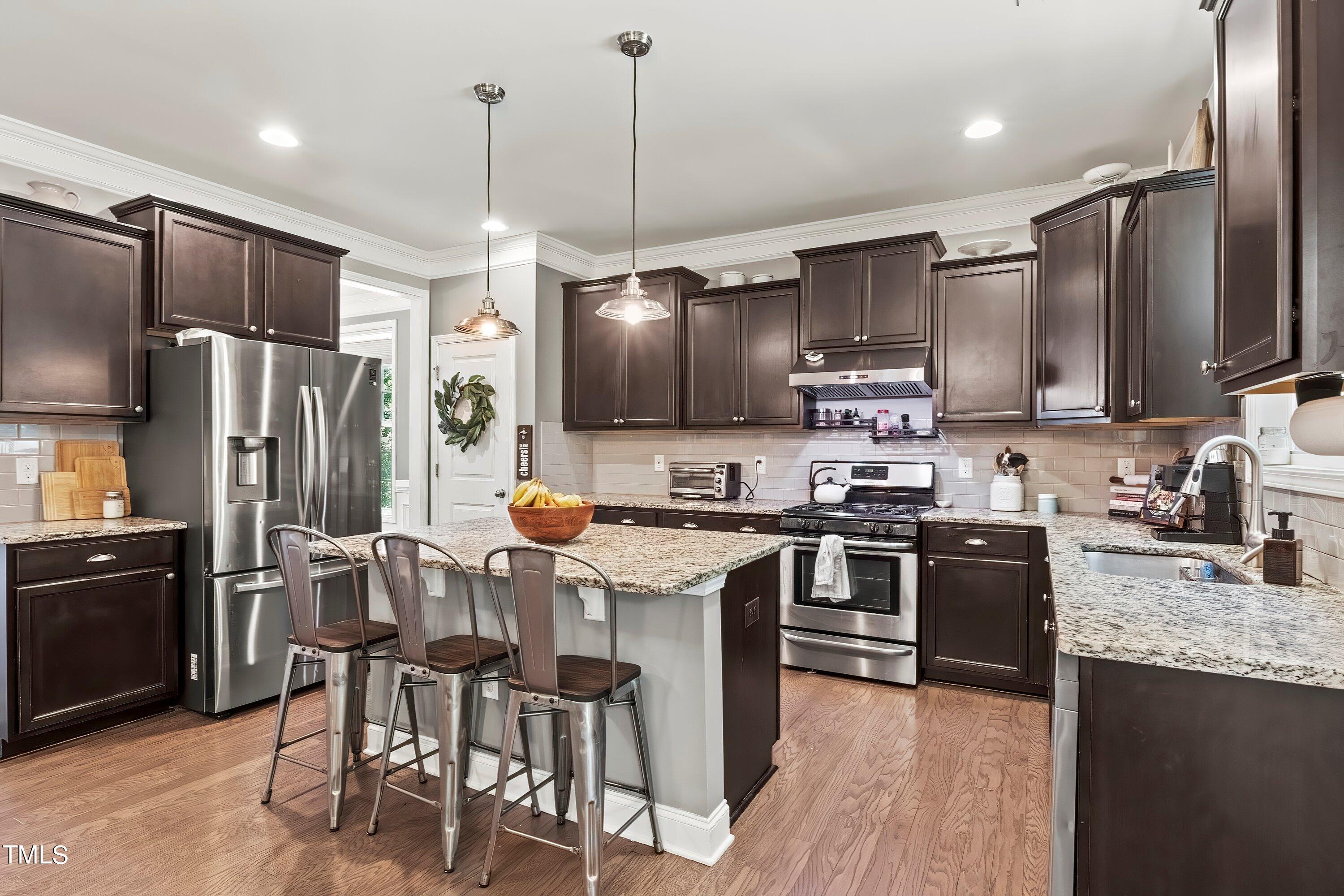 7406 Randshire Way Raleigh, NC 27616 - Photo 12 of 38 a kitchen with stainless steel appliances granite countertop a stove refrigerator and cabinets