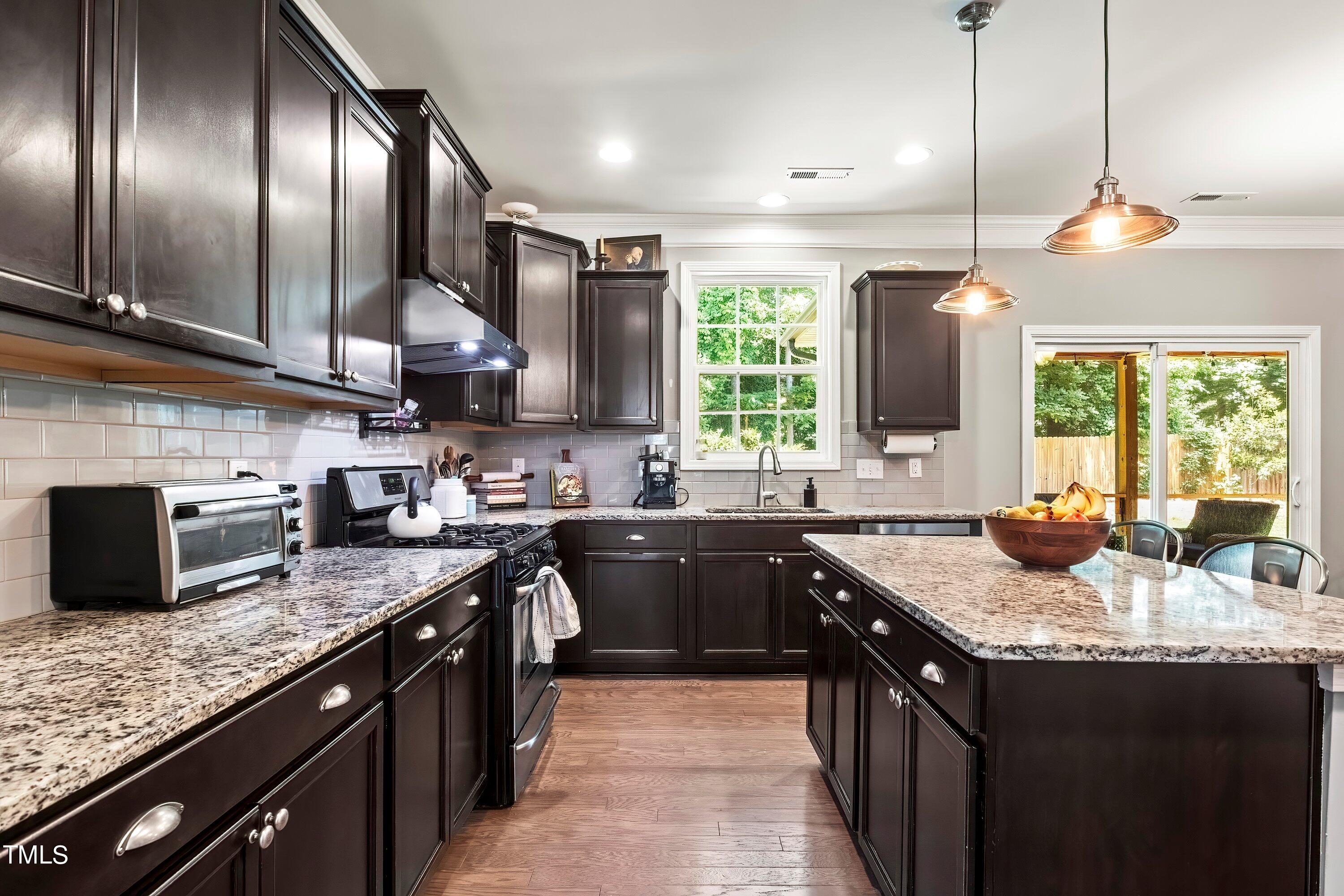 7406 Randshire Way Raleigh, NC 27616 - Photo 16 of 38 a kitchen with stainless steel appliances granite countertop counter space a sink a stove and a wooden floor