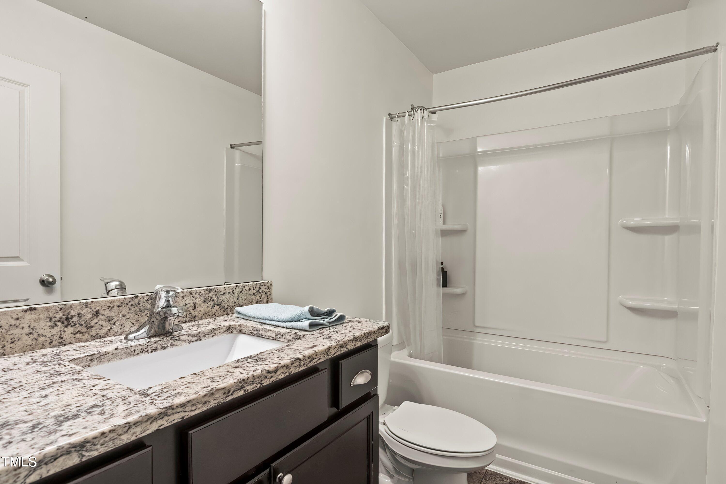 7406 Randshire Way Raleigh, NC 27616 - Photo 31 of 38 a bathroom with a granite countertop sink toilet and shower