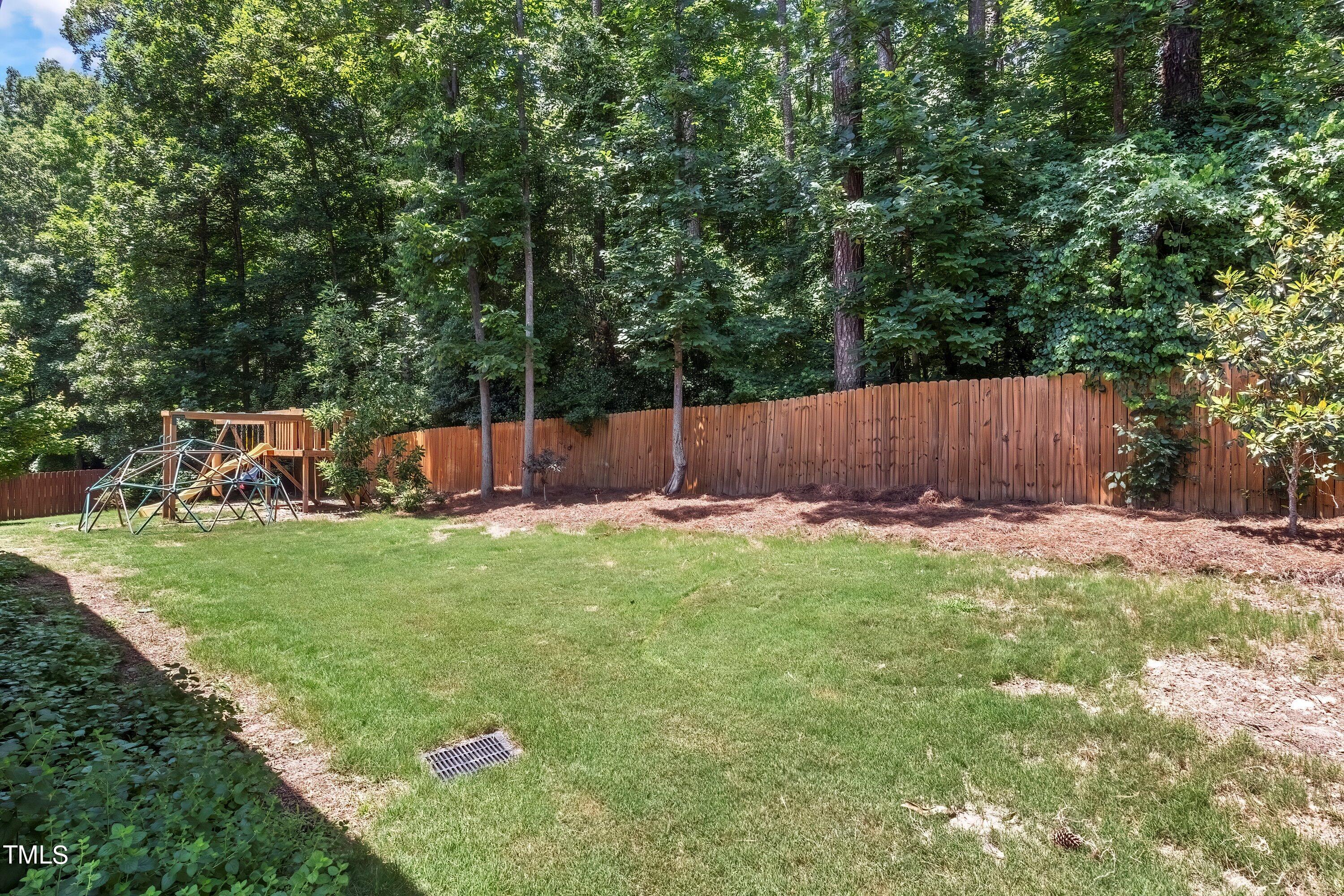 7406 Randshire Way Raleigh, NC 27616 - Photo 37 of 38 a view of a backyard with a large tree and wooden fence