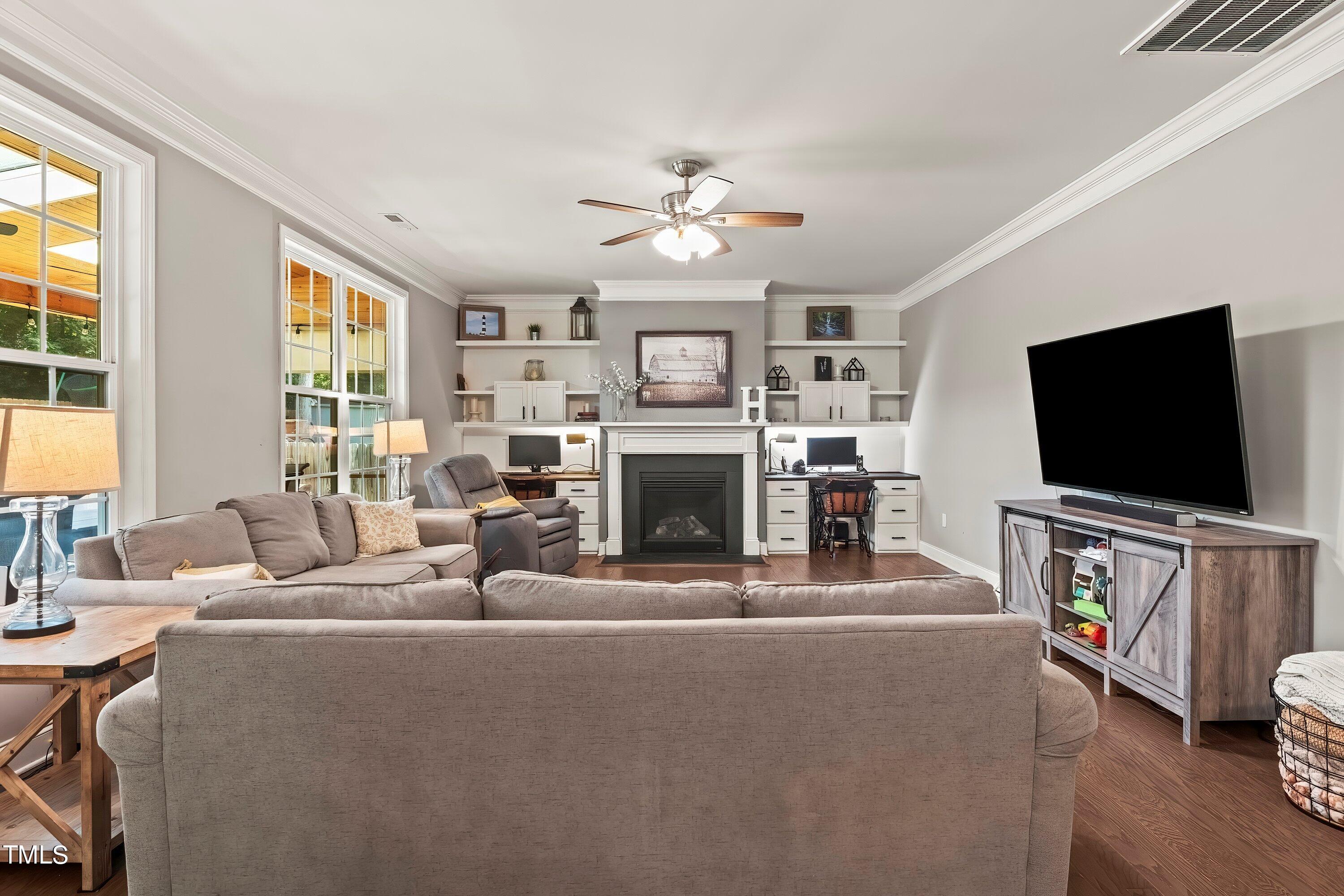 7406 Randshire Way Raleigh, NC 27616 - Photo 7 of 38 a living room with furniture a flat screen tv and a fireplace