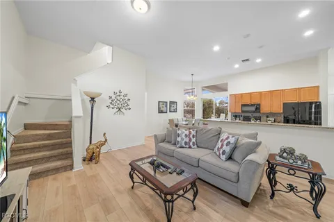 a living room with furniture and a view of kitchen