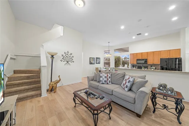 a living room with furniture and a view of kitchen