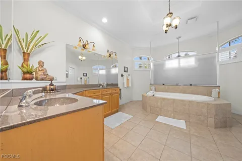 a spacious bathroom with a granite countertop sink a mirror and a bathtub
