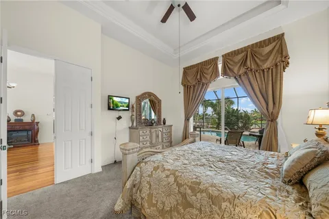 a bedroom with a bed a large window and mirror