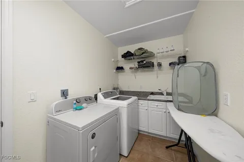 a utility room with sink dryer and washer