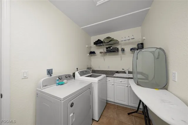a utility room with sink dryer and washer
