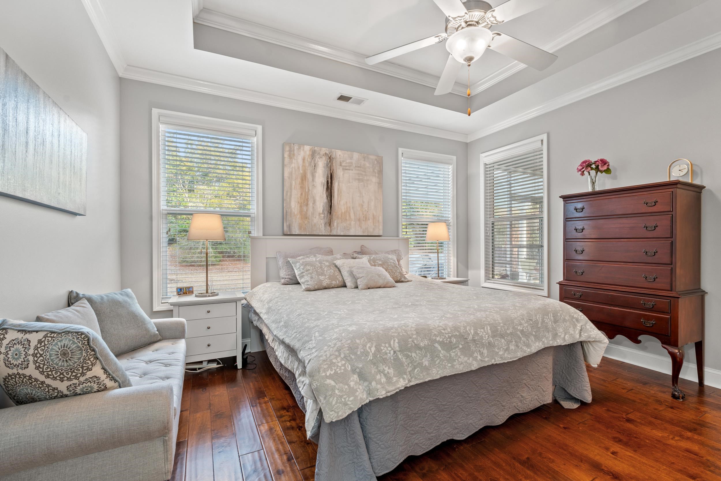 1979 Suncrest Drive Myrtle Beach, SC 29577 - Photo 19 of 28 Bedroom featuring ornamental molding, dark wood finished floors, multiple windows, a raised ceiling, and a ceiling fan
