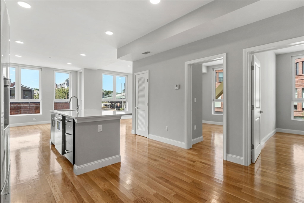 10 Taber Street, Unit 501 Boston, MA 02119 - Photo 9 of 35 a living room with stainless steel appliances kitchen island granite countertop wooden floors and view living room