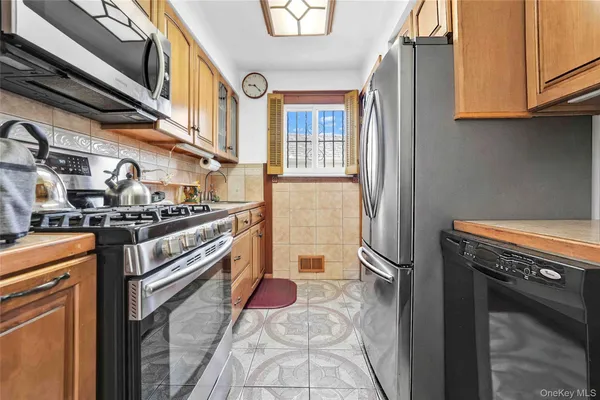 a kitchen with stainless steel appliances granite countertop a stove a washer and dryer