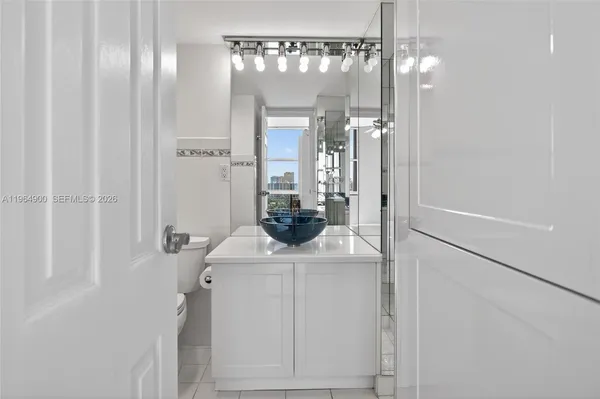a bathroom with a granite countertop sink a toilet and shower