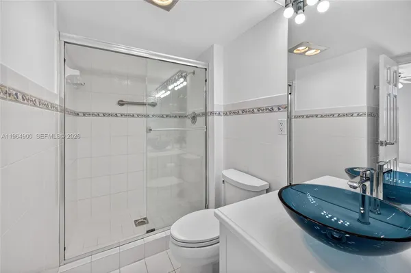 an empty room with chandelier fan and windows