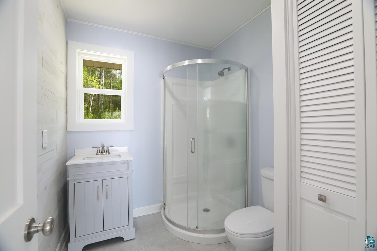 3739 Sundling Road Tower, MN 55790 - Photo 6 of 15 Bathroom featuring tile floors, walk in shower, toilet, and vanity