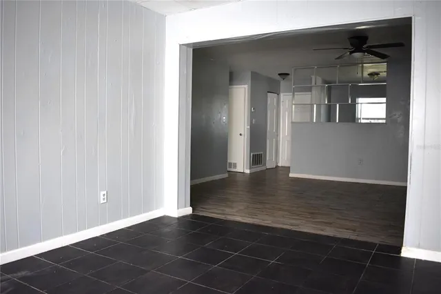 an empty room with wooden floor and cabinet