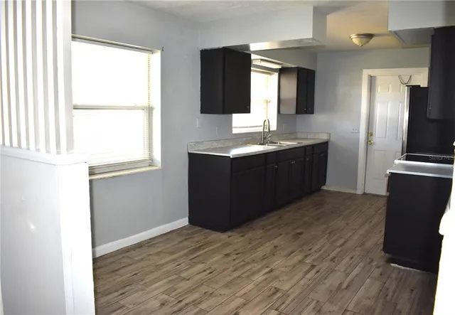 a kitchen with stainless steel appliances granite countertop a sink and a wooden floor