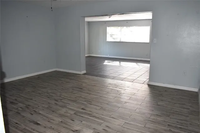 a view of empty room with wooden floor