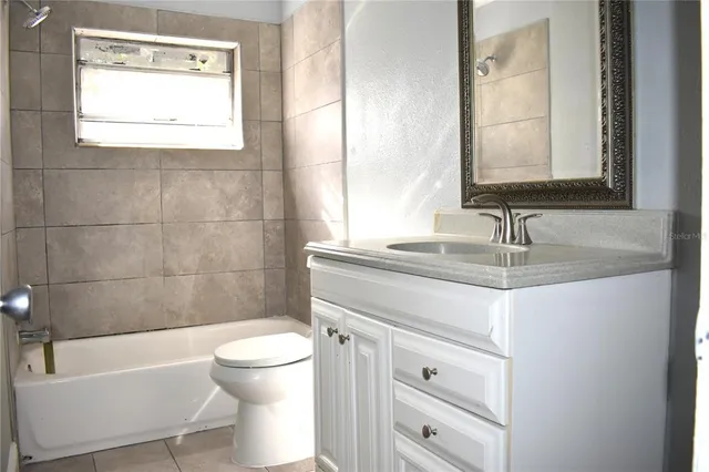 a bathroom with a granite countertop toilet sink and mirror