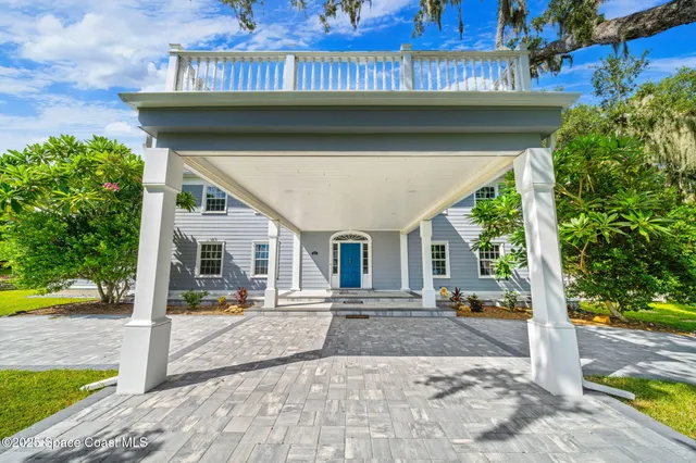 a dining room with chandelier and wooden floor