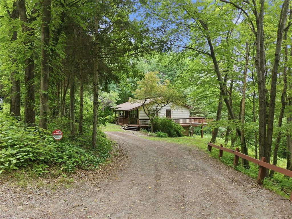 520 Highland Hill Road Jim Thorpe, PA 18235 - Photo 3 of 83 A secluded retreat awaits, nestled among verdant trees with a welcoming deck for tranquil forest views.