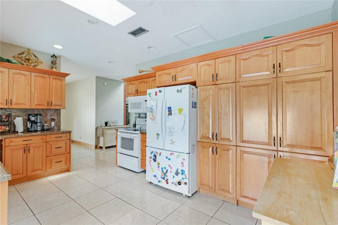 8067 Buttonwood Circle Tamarac, FL 33321 - Photo 17 of 33 a kitchen with stainless steel appliances granite countertop a refrigerator and cabinets
