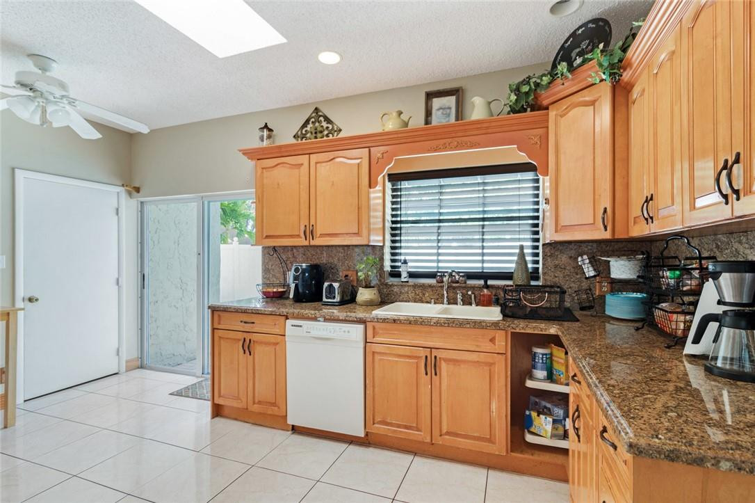 8067 Buttonwood Circle Tamarac, FL 33321 - Photo 2 of 33 a kitchen with stainless steel appliances granite countertop a stove a sink and a microwave
