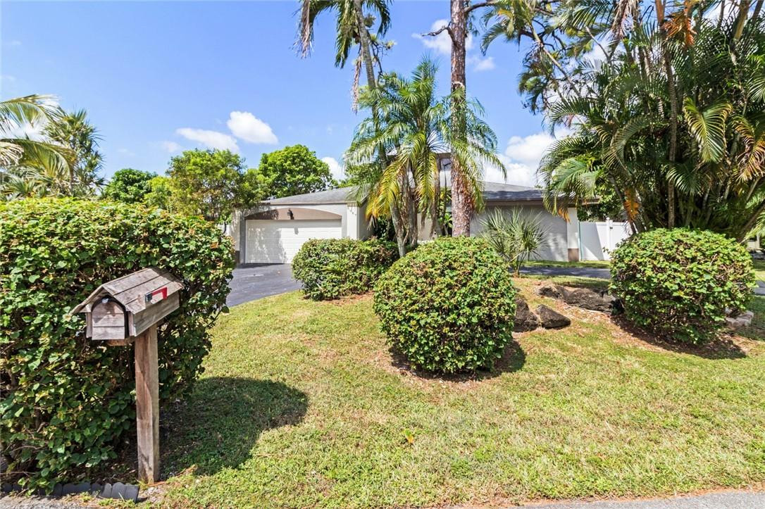 8067 Buttonwood Circle Tamarac, FL 33321 - Photo 32 of 33 a front view of a house with a yard and a garden