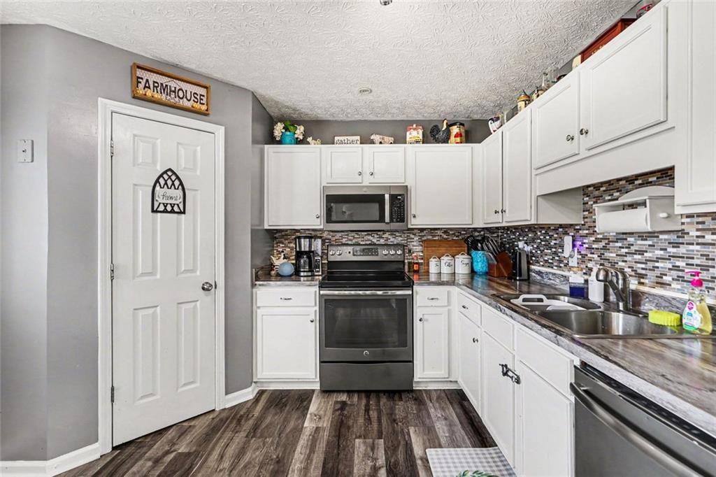 302 Fairview Lane Dallas, GA 30157 - Photo 10 of 26 a kitchen with granite countertop a sink and a stove top oven