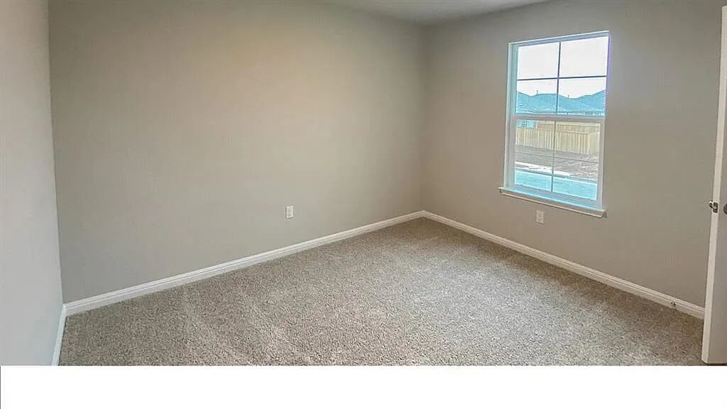 10612 Gonzales Ranger Pass Austin, TX 78754 - Photo 17 of 19 Plush carpeting and a classic multi-pane window enhance this versatile secondary bedroom space.