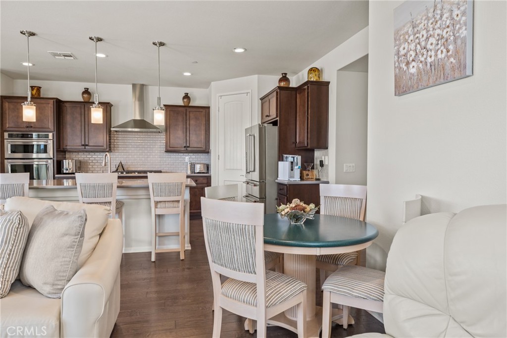 11636 Cascade Street Apple Valley, CA 92308 - Photo 12 of 70 a dining room with furniture a rug and kitchen view
