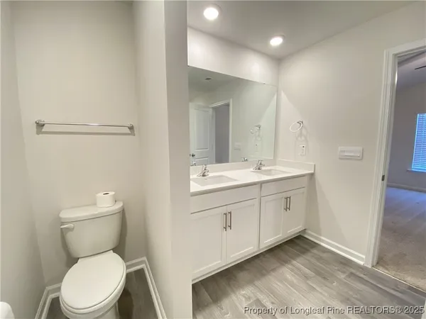 a bathroom with a toilet a sink a mirror and vanity