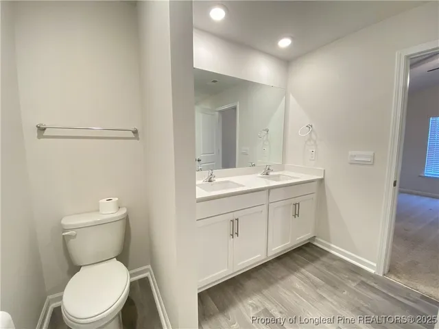 a bathroom with a toilet a sink a mirror and vanity